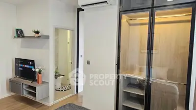 Modern living room with sleek TV unit and glass cabinet in stylish apartment.