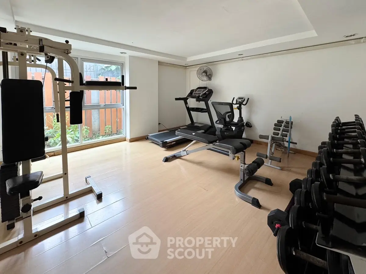 Spacious home gym with modern exercise equipment and natural light.