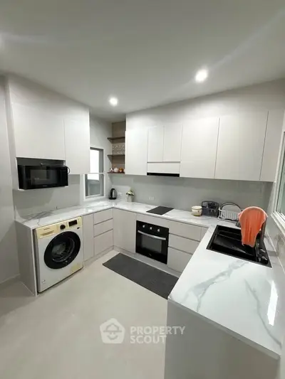 Modern kitchen with sleek white cabinets and built-in appliances
