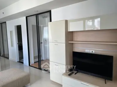 Modern living room with sleek furniture and glass doors in a contemporary apartment.