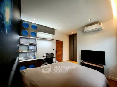 Modern bedroom with study area, featuring sleek design and ample storage space.