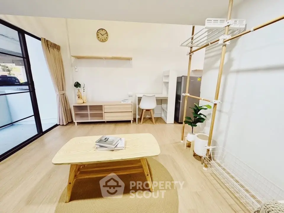 Modern minimalist living room with natural light and stylish wooden furniture.