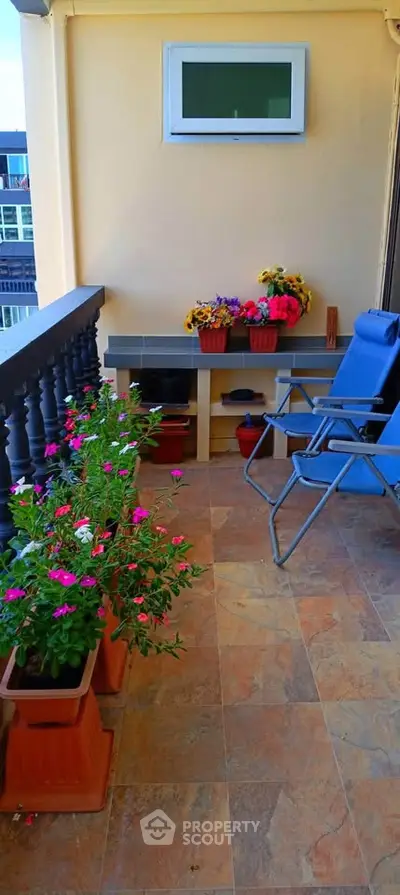 Charming balcony with vibrant flowers and cozy seating, perfect for relaxation and enjoying outdoor views.