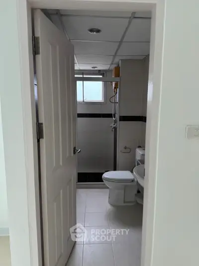 Modern bathroom with shower and toilet in sleek white and gray design