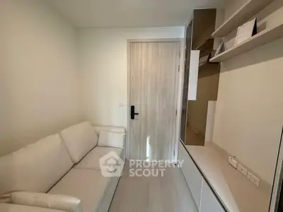 Cozy small living room with modern white sofa and sleek storage solutions.