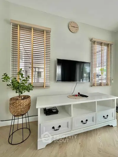 Modern living room with stylish TV stand, wall-mounted TV, and elegant decor, perfect for cozy family gatherings.