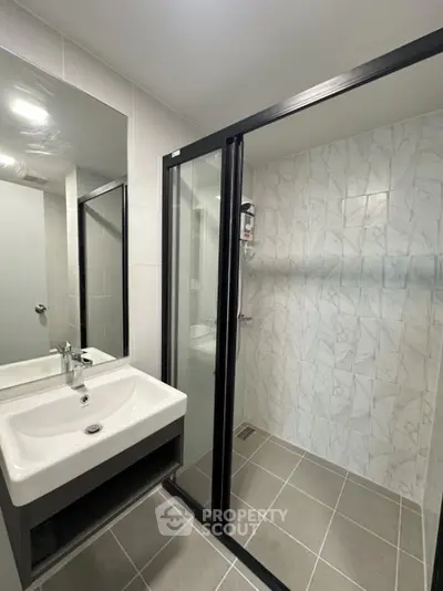 Modern bathroom with sleek shower enclosure and stylish sink in contemporary design.