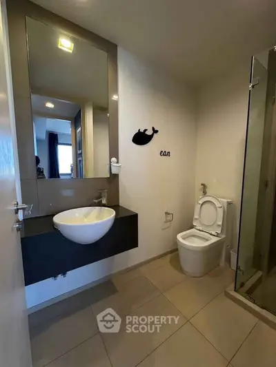 Modern bathroom with sleek fixtures and glass shower enclosure