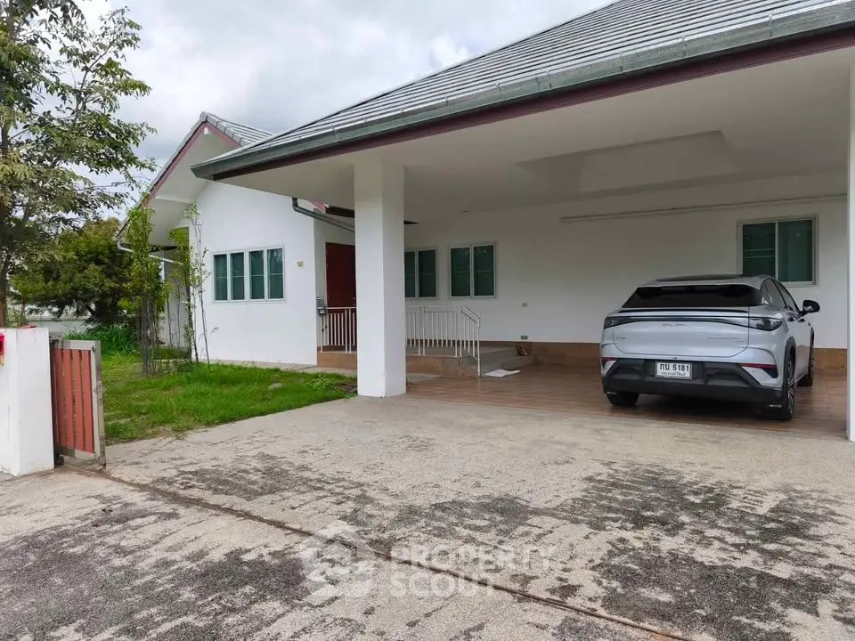 Modern house with spacious driveway and sleek car parked, showcasing contemporary architecture and lush greenery.