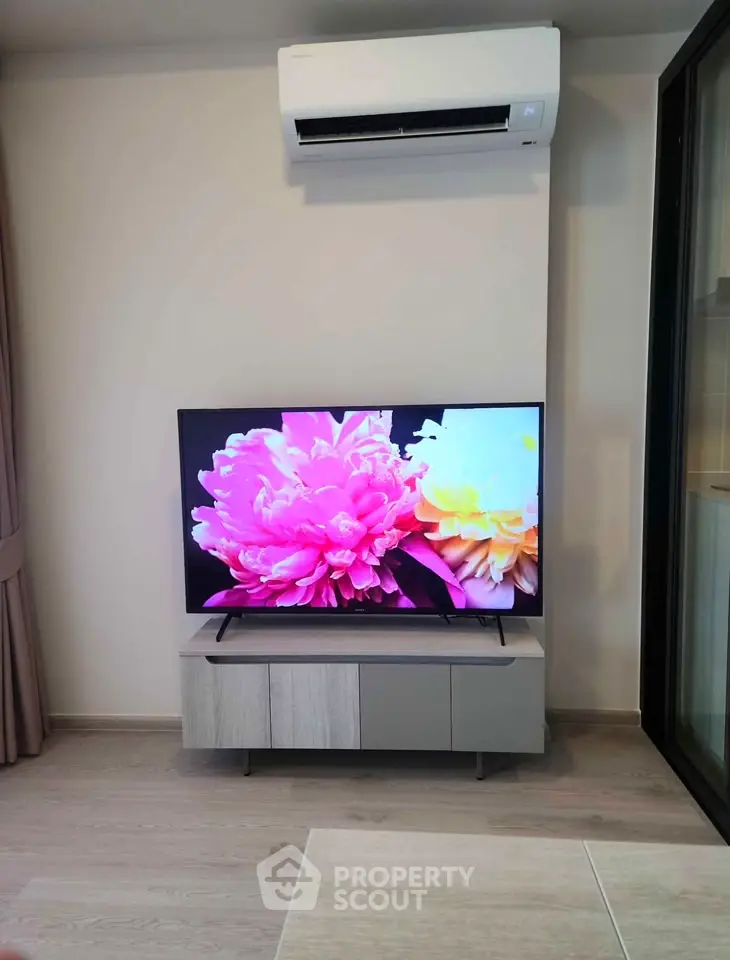 Modern living room with sleek TV setup and air conditioning unit, perfect for cozy entertainment.