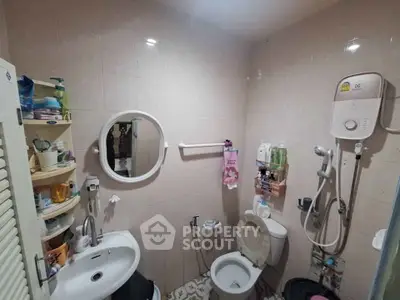 Compact bathroom with shower, sink, and toilet in a cozy real estate unit.