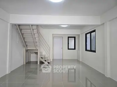 Spacious modern interior with sleek staircase and glossy tiled flooring, perfect for customization.