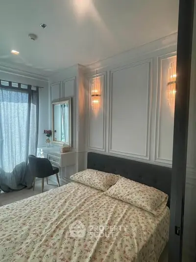 Elegant bedroom with floral bedding, stylish wall sconces, and a cozy vanity area by the window.