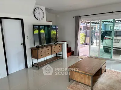 Spacious living room with modern decor and large sliding glass doors leading to a carport.