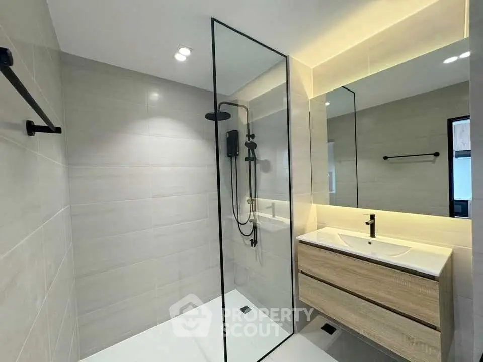 Modern bathroom with sleek glass shower and stylish vanity in contemporary home.