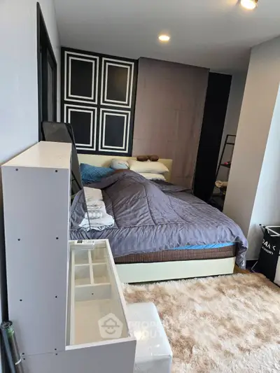 Cozy bedroom with modern decor and plush carpet, perfect for relaxation.