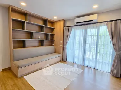 Spacious living room with built-in shelves and large windows for natural light.