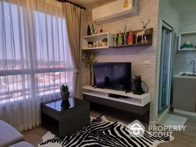 Cozy living room with modern decor, featuring a wall-mounted TV, chic floating shelves, and a large window with sheer curtains offering ample natural light.