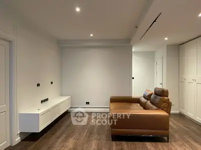 Modern living room with brown leather sofa and sleek cabinetry