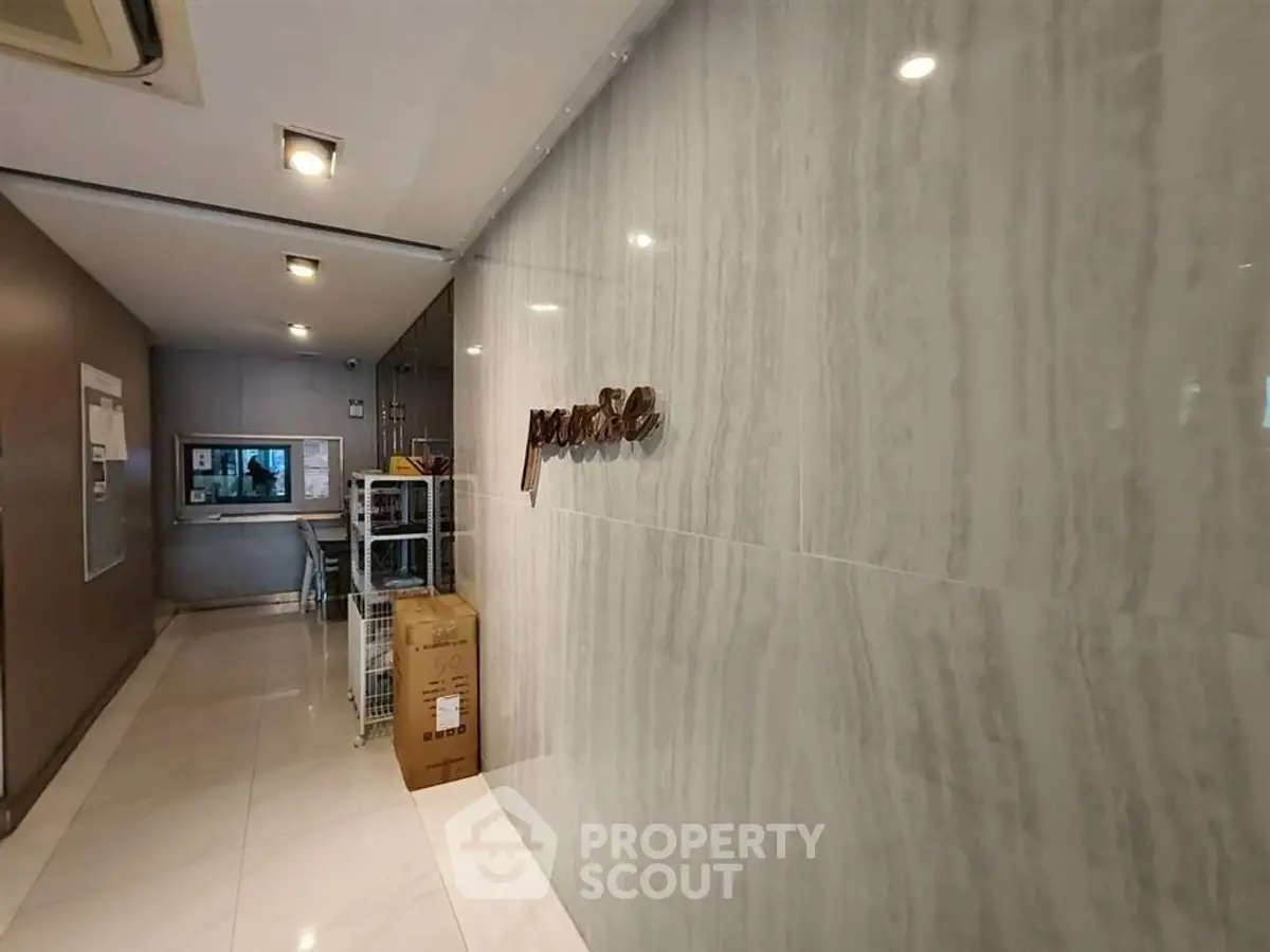 Modern building entrance with marble walls and sleek design, showcasing luxury and elegance.