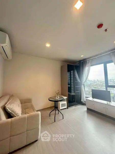 Modern living room with city view, cozy sofa, and sleek furniture.