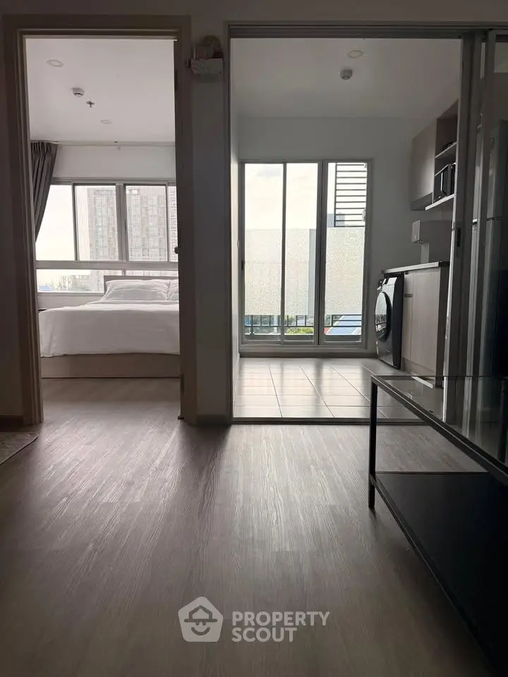 Modern apartment interior with bedroom, living area, and balcony view.