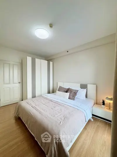 Spacious bedroom with modern decor and ample natural light, featuring a cozy bed and stylish wardrobe.