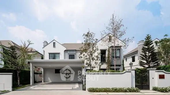 Elegant modern house exterior with spacious driveway and lush landscaping.