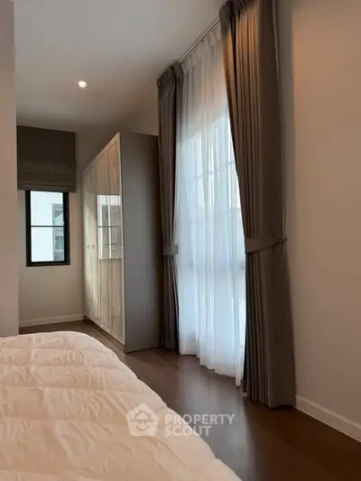 Cozy bedroom with elegant curtains and wooden flooring