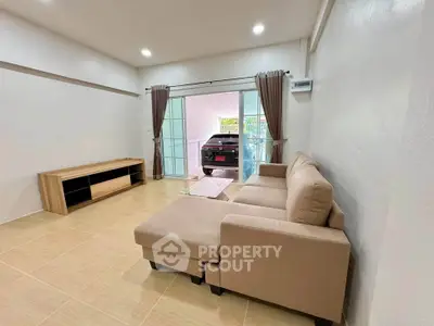 Spacious living room with modern sofa and view of garage through glass doors.