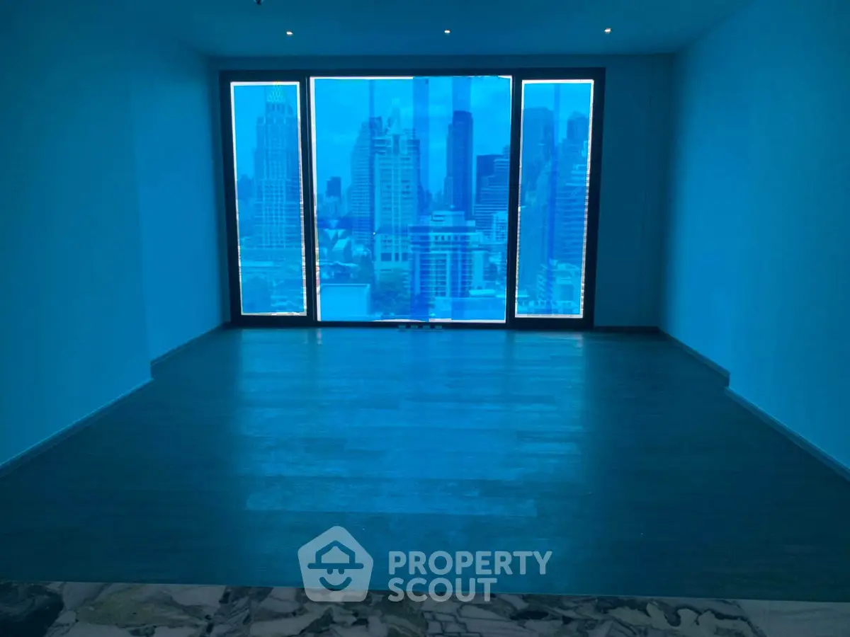 Spacious living room with stunning city skyline view through large windows.