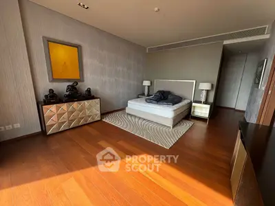 Luxurious bedroom with elegant decor and hardwood flooring, featuring a stylish bed and modern furniture.