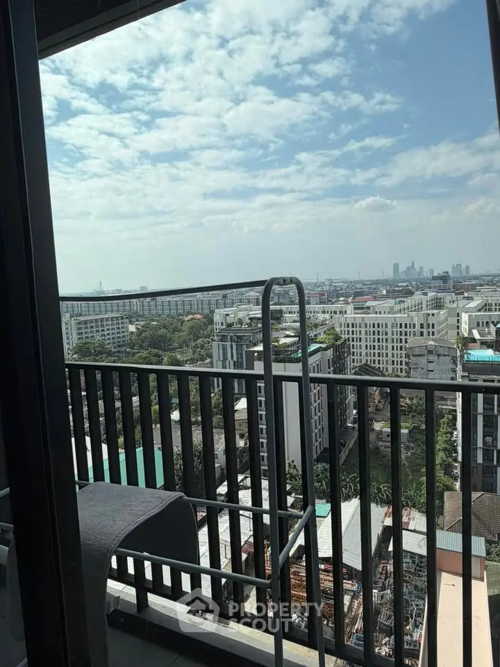 Stunning cityscape view from a high-rise balcony with clear skies and modern architecture.