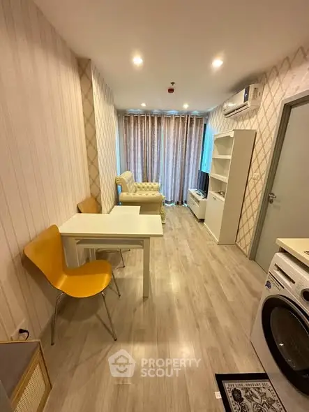 Modern living room with stylish furniture and washing machine, featuring elegant lighting and wood flooring.