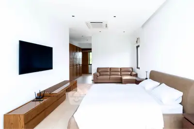 Spacious modern bedroom with sleek design and cozy seating area