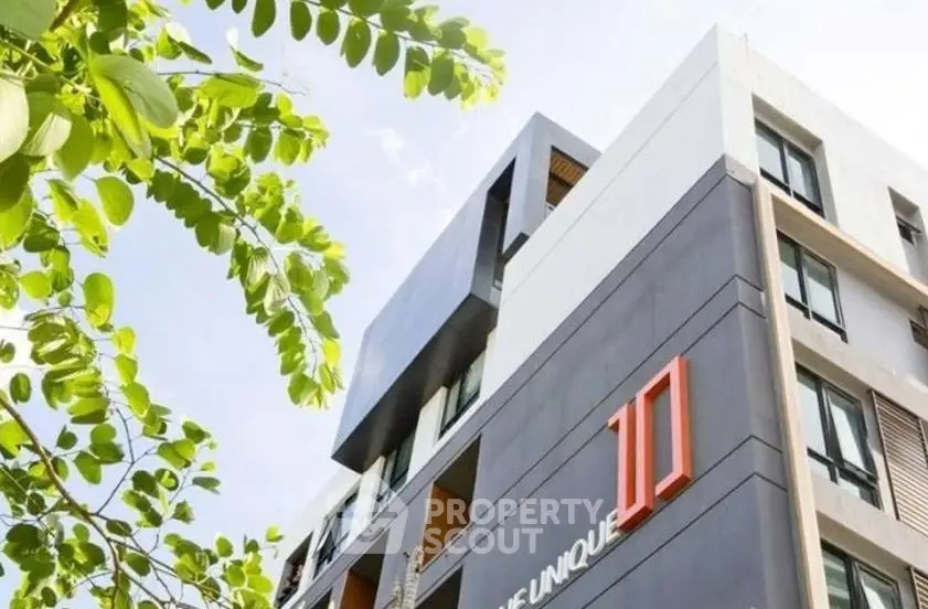Modern apartment building exterior with unique architectural design and lush greenery.