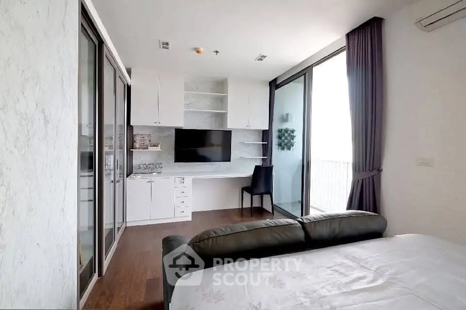 Modern bedroom with built-in desk and large windows offering natural light