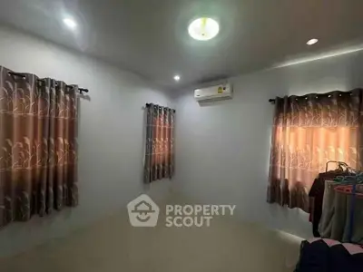 Spacious bedroom with air conditioning and elegant curtains, perfect for comfort and relaxation.