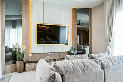 Luxurious living room with modern decor and large flat-screen TV, perfect for relaxation and entertainment.