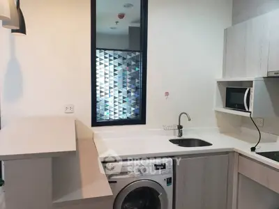 Modern kitchen with washing machine and microwave in compact layout
