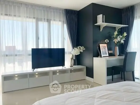 Modern bedroom with sleek TV setup and stylish desk area
