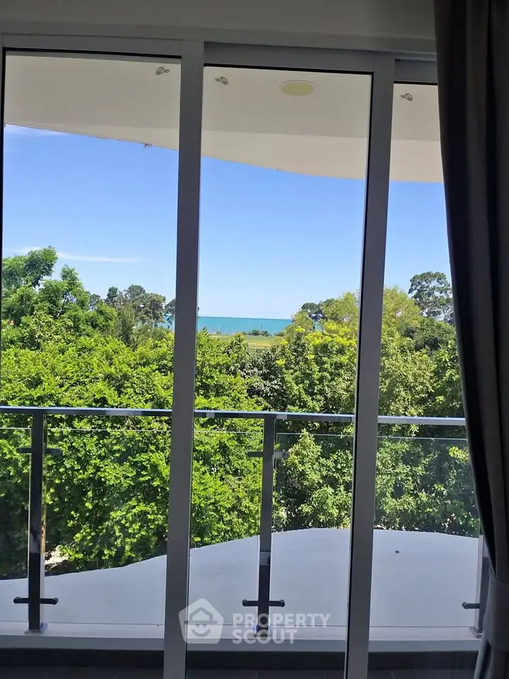 Stunning balcony view overlooking lush greenery and ocean horizon