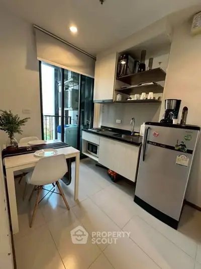 Modern kitchen with sleek appliances and dining area in a stylish apartment