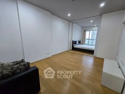 Spacious modern apartment with wooden flooring and large windows offering city views.