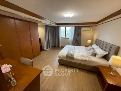 Spacious bedroom with city view, elegant decor, and modern furnishings.