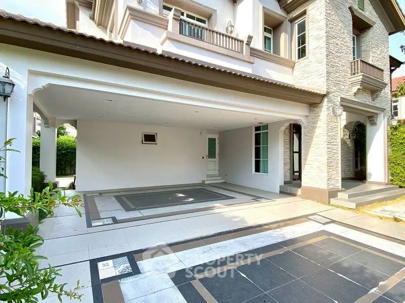 Spacious modern home exterior with elegant stone facade and large driveway.