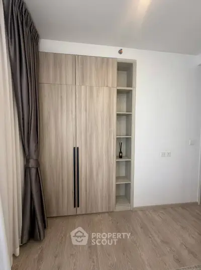 Modern bedroom with sleek wooden wardrobe and elegant curtains