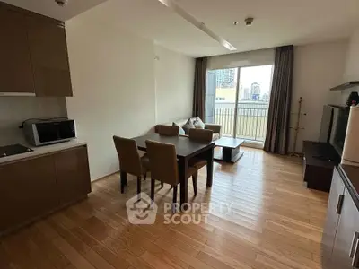 Modern living room with dining area and balcony view in a stylish apartment.