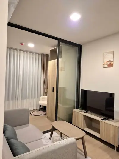 Modern living room with sleek furniture and TV, featuring a cozy ambiance and stylish decor.