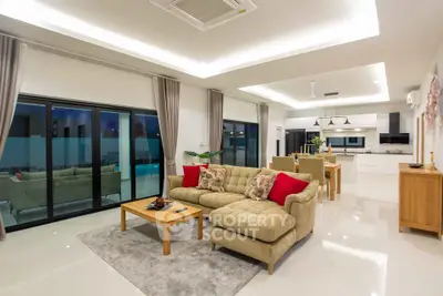 Spacious modern living room with open kitchen, elegant decor, and large windows for natural light.